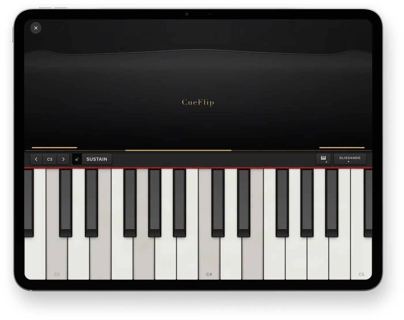 CueFlip’s piano on iPad Pro, held landscape: a black lid with CueFlip in gold, two octaves of keys from C3 to C5 with a few held down, and the Sustain and Glissando switches.